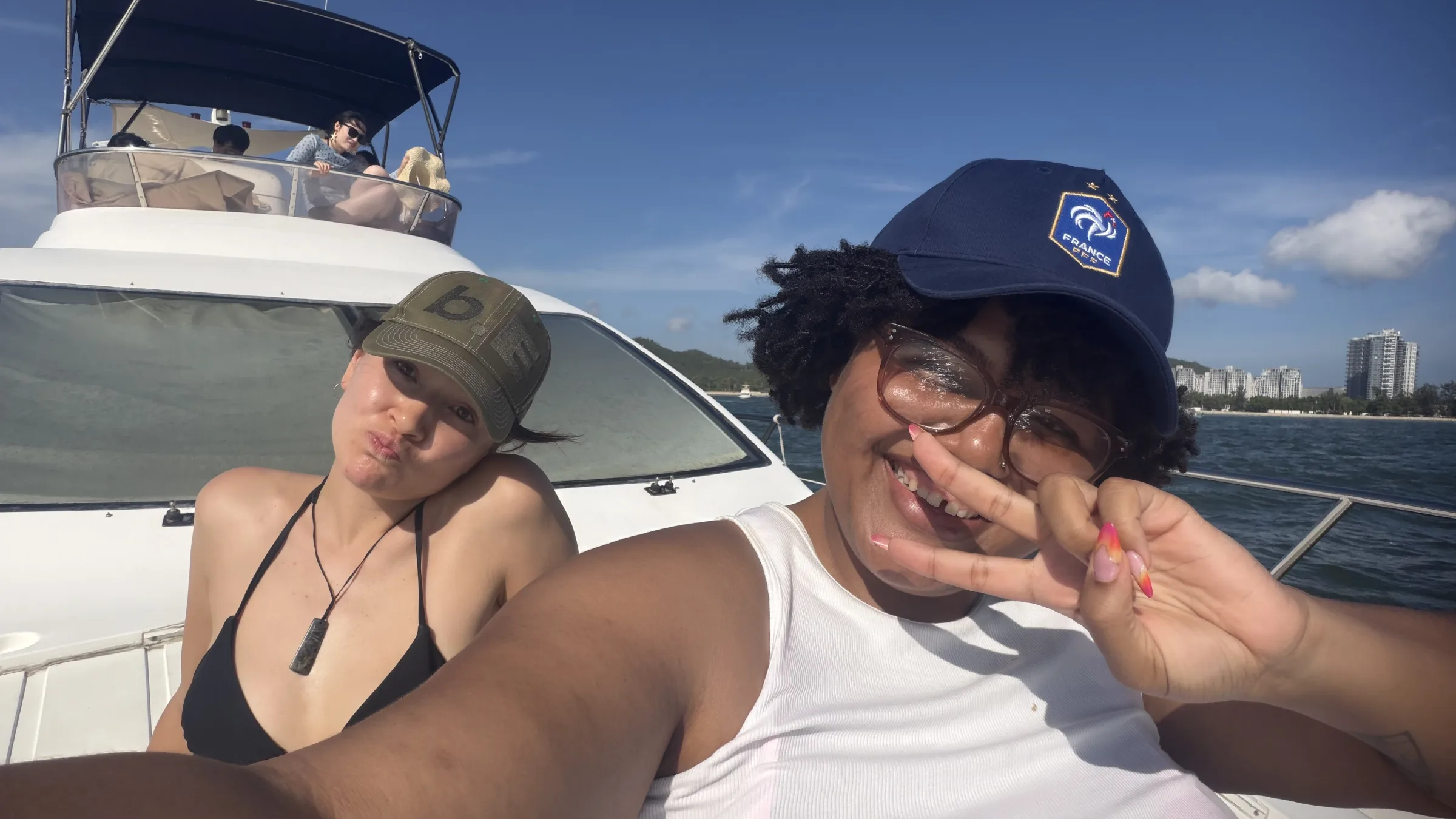 Two members on a boat, throwing peace signs