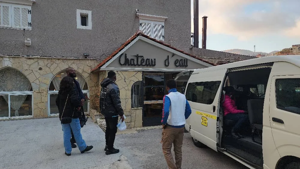 Members boarding the minibus outside Chateau d'eau