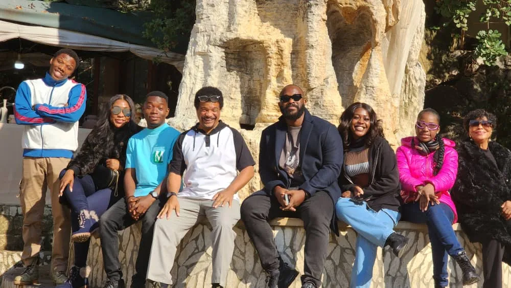 The whole group seated together across the rock formations