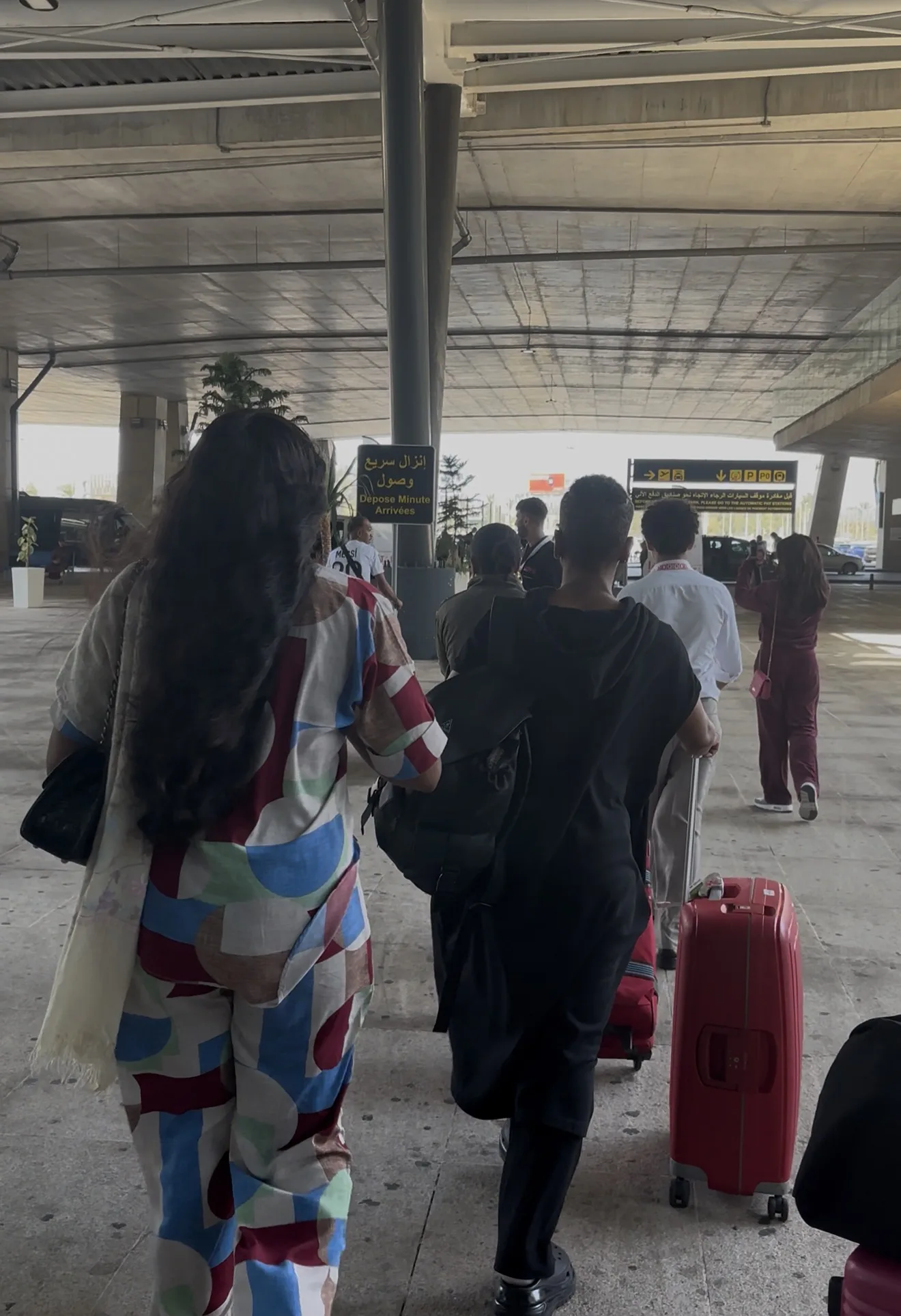 A member walking the terminal with her luggage