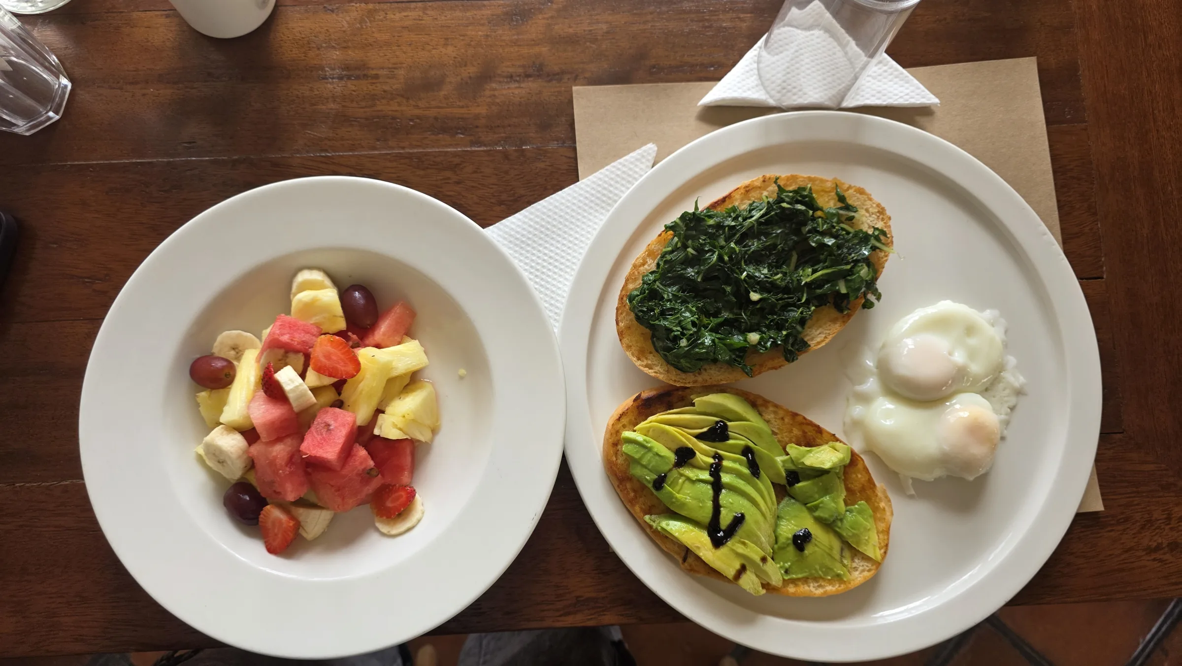 Breakfast laid out - avocado toast, eggs and fresh fruit