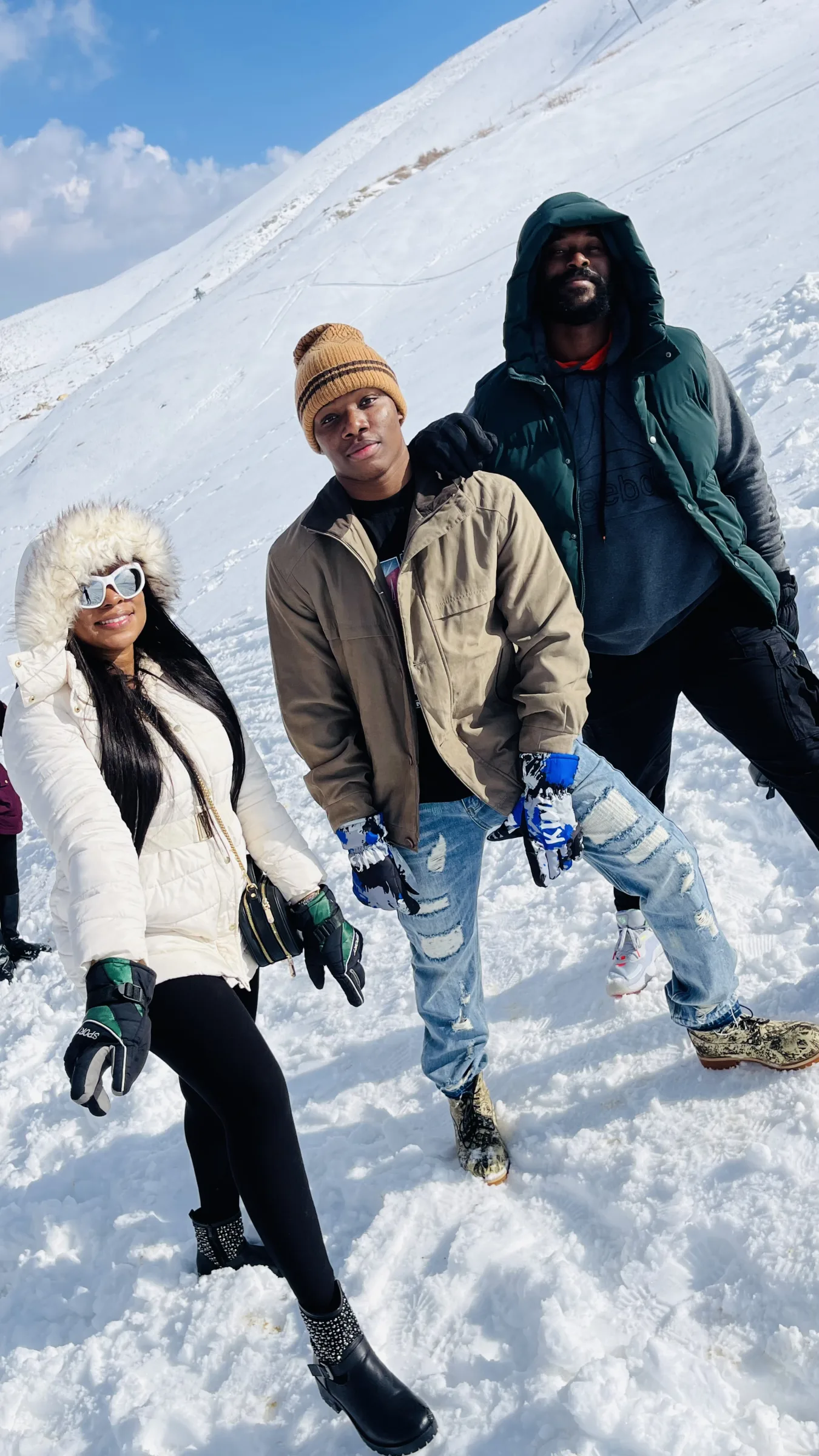 Three travellers standing on a snow-covered mountainside